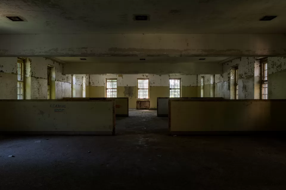 Abandoned wing of Creedmoor Hospital, Queens New York with long row of windows and 'Reading Room' visible on wall
